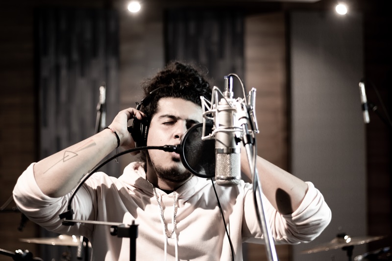 El cantautor Braulio Jacob canta frente a un micrófono en un estudio de grabación 